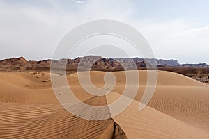 Dasht-e Kavir desert sand dunes with mountains on.