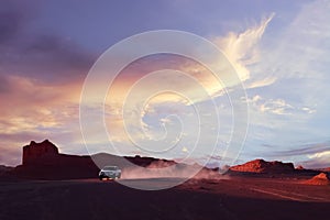 Dasht e Lut desert in Iran. The car in motion on the background of the sunset. Wild nature of Persia