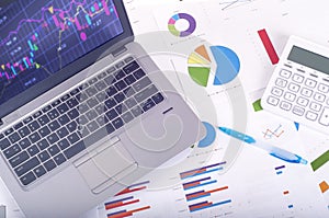 Data analysis - workplace with business graphs and charts, laptop and calculator