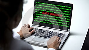 Data breach attack on laptop computer, woman working in office, cybercrime