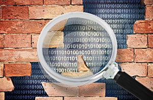 Data Breach concept with cracked brick wall and binary code - Concept seen through a magnifying glass