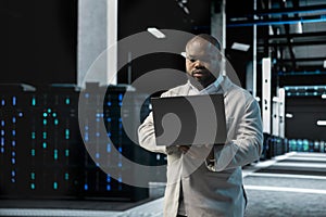 Data center computer scientist using laptop to protect servers