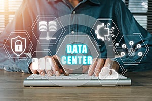 Person hand typing on keyboard computer with data center icon on virtual screen