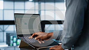 Data center engineer coding on notebook, adjusting power settings