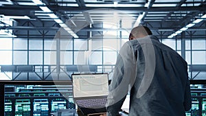 Data center engineer coding on notebook, adjusting power settings