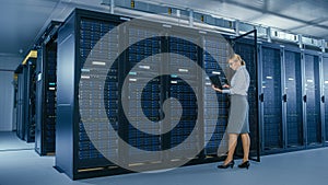 In Data Center: Female IT Technician Stand Near Opened Rack Cabinet and Runs Maintenance Program o