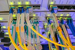 Data center. A lot of optical links are lit on the front panel of the central Internet router. Fiber-optic wires are connected to