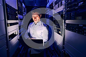 Data center IT worker staring at his notebook computer