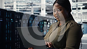 Programmer in data center using laptop to deploy new server architecture