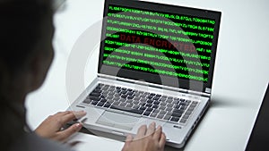 Data encrypted on laptop computer, woman working in office, cybercrime, close up