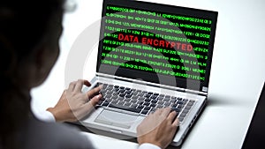 Data encrypted on laptop computer, woman working in office, cybercrime, close up