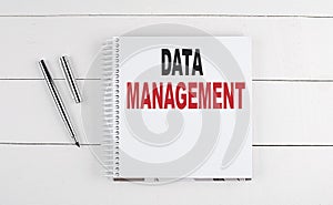 DATA MANAGEMENT text written on notebook on the wooden background