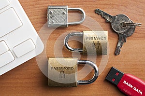 Data protection concept: three locks, an usb key and a pair of key on a wooden table