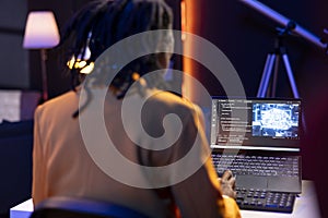 Data scientist using laptop in home office, updating artificial intelligence