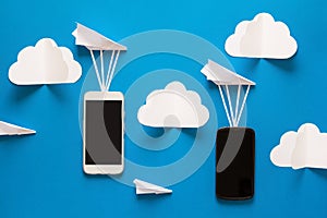 Data transfer concept. Message passing. Two mobile smartphones and paper airplanes