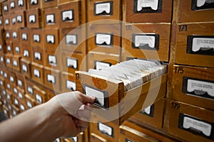 Database cabinet and human hand opens card drawer photo