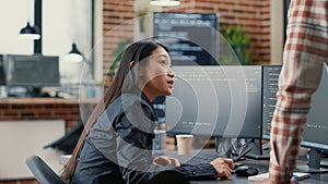 Database developer pointing pencil at computer screen with software compiling code explaining source algorithm to