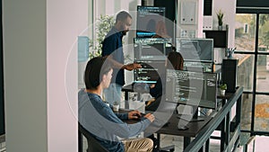 Database programer writing code on computer in software company office
