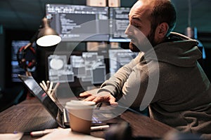 Database programmer writing code on multiple screens