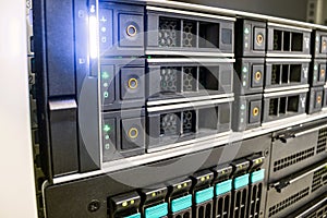 The database server is in the rack of the data center. Modern computer equipment is installed in the server room. Many hard drives
