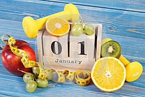 Date of 1 January on cube calendar, fruits, dumbbells and tape measure, new years resolutions
