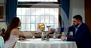 Date of adult man and woman in luxury restaurant, clinking glasses and drinking wine