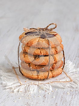 Tahini date cookies are stacked on a white wooden table