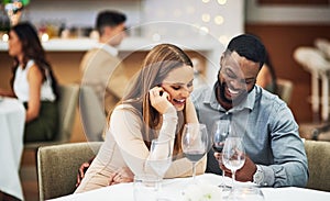 Date, laughing and interracial couple with wine in fine dining, luxury restaurant or valentines celebration together