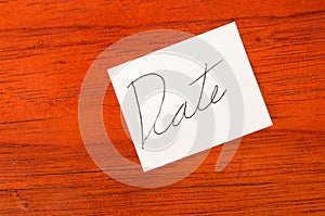 Date- Post it Note on Wood Background