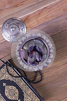 Dates with Beads and quran on wooden background top view.-Ramadan kareem/Eid al fitr Concept