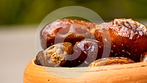 Dates in clay bowl on background.