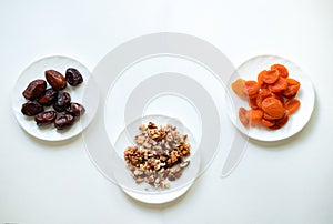 Dates, dried apricots, walnuts on a white background