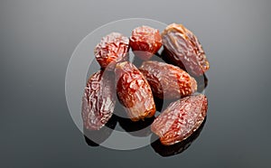 Dates fruit. Date fruits on black background. Heap of Medjool dates close up. Tasty healthy Food