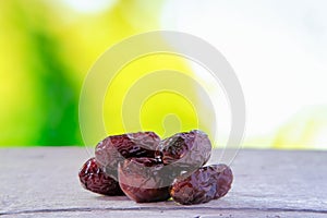 Dates fruit. Ramadan food also known as kurma over greeny nature background.