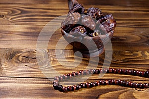 Dates fruit and rosary on wooden table