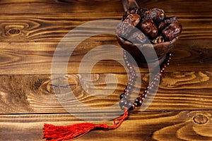 Dates fruit and rosary on wooden table