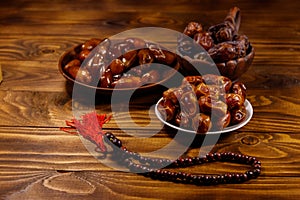 Dates fruit and rosary on wooden table
