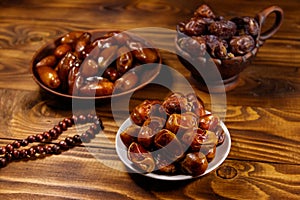 Dates fruit and rosary on wooden table