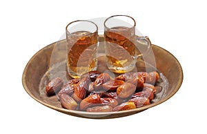 Dates fruit and tea in golden tray on white background