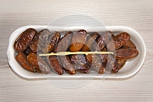 Dates in plastic package on wooden background. Top view. Ripe, neatly stacked.