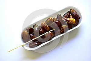 Dates are ripe and delicious on a white plastic backing