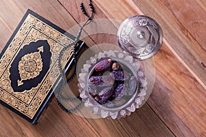 Dates with rosary and holy quran on wooden background top view.-Ramadan kareem/Eid al fitr Concept