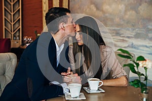 Dating in the cafe. Beautiful young couple sitting in the cafe, drinking coffee Love, dating