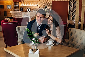 Dating in the cafe. Beautiful young couple sitting in the cafe, drinking coffee Love, dating