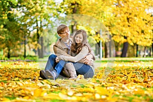 Dating couple in yellow leaves on a fall day