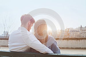 Dating or first love, young couple sitting together on the bench