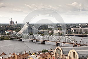 Daugava river in Riga, latvia, from above with dzelzcela tilts or Riga Railway Bridge with a skyline of business skyscrapers in photo