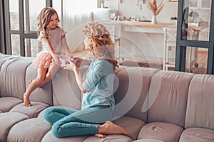 Daugher and mother sitting on the couch and celebration mothers day with the present