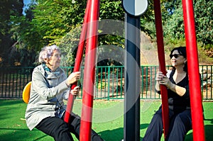 A daughter brought her elderly mother to an outdoor fitness field in the neighborhood.