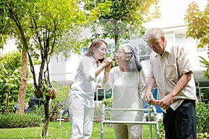 Daughter caring for elderly parents Take a walk in the garden for physical therapy to stay healthy.